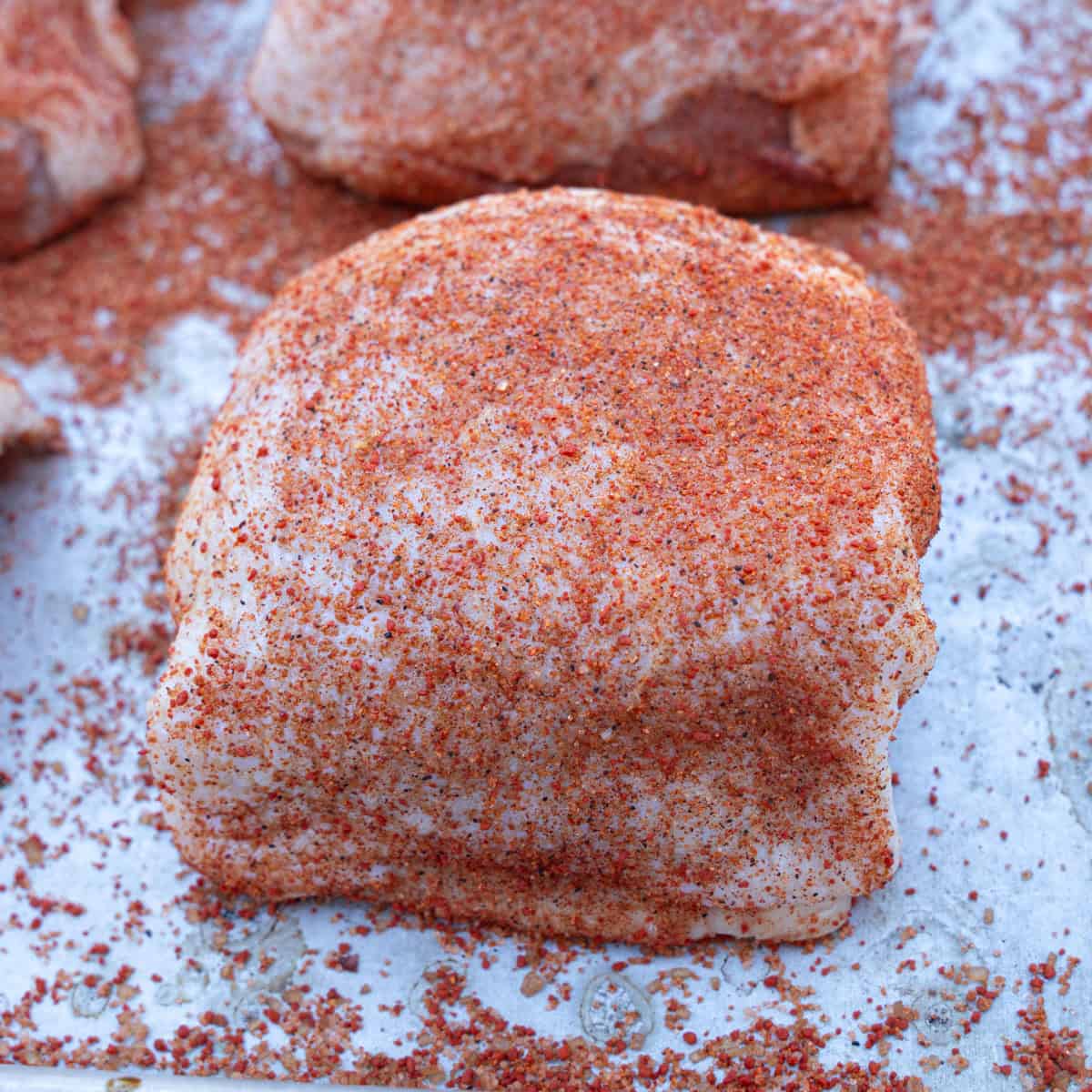 Chicken Thighs being seasoned
