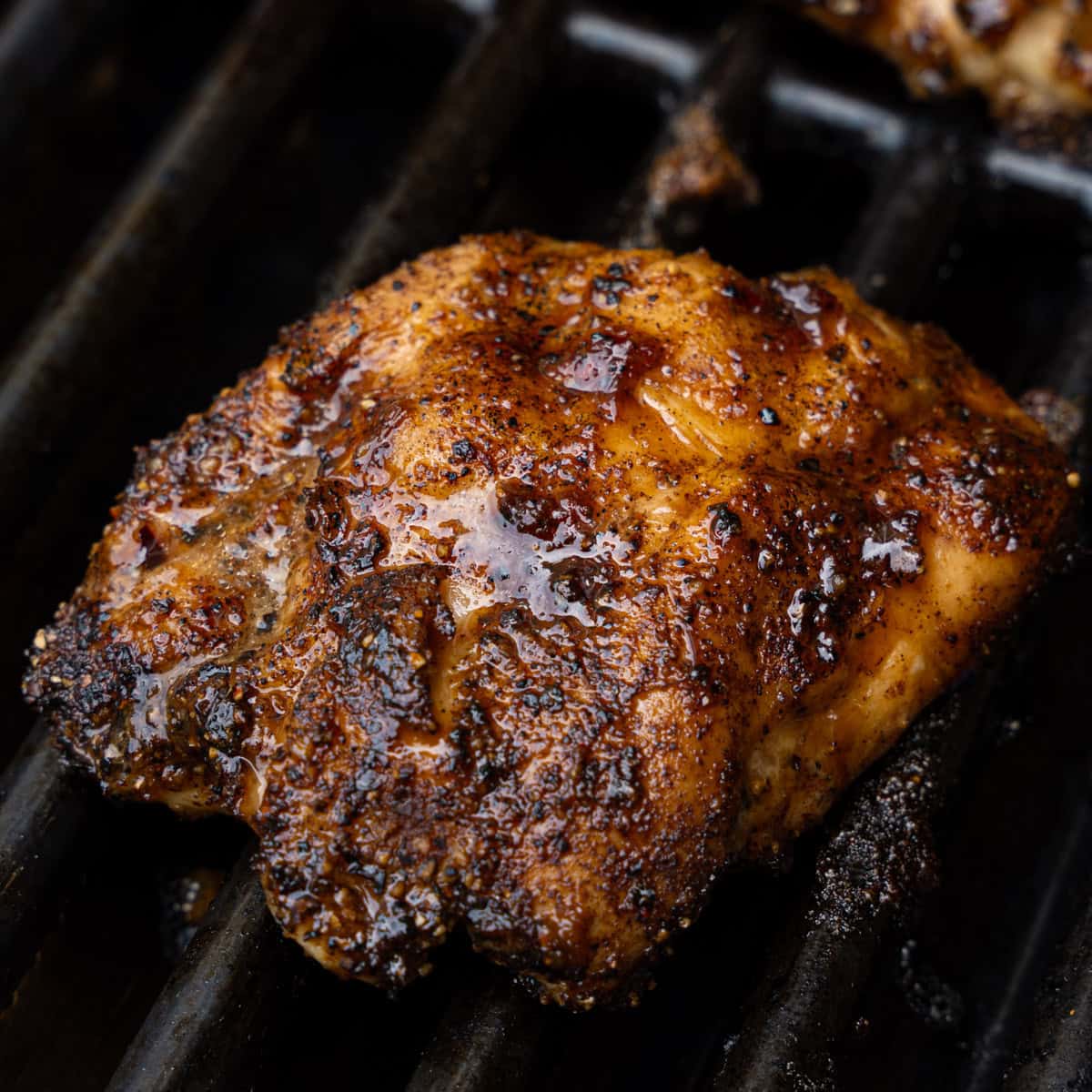 chicken on the grill after being mopped with bbq sauce