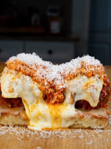 Meatball Sub topped with melted provolone cheese, marinara sauce, and grated parmesan cheese
