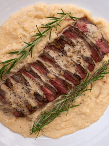 Prepared Three Cheese Grits served with grilled flank steak