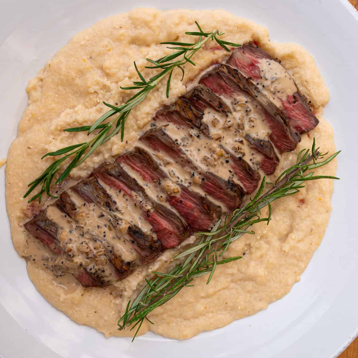 Prepared Three Cheese Grits served with grilled flank steak