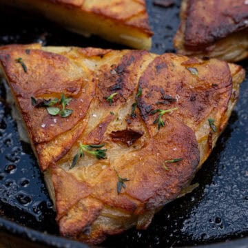 pommes anna potatoes seared in a cast iron skillet