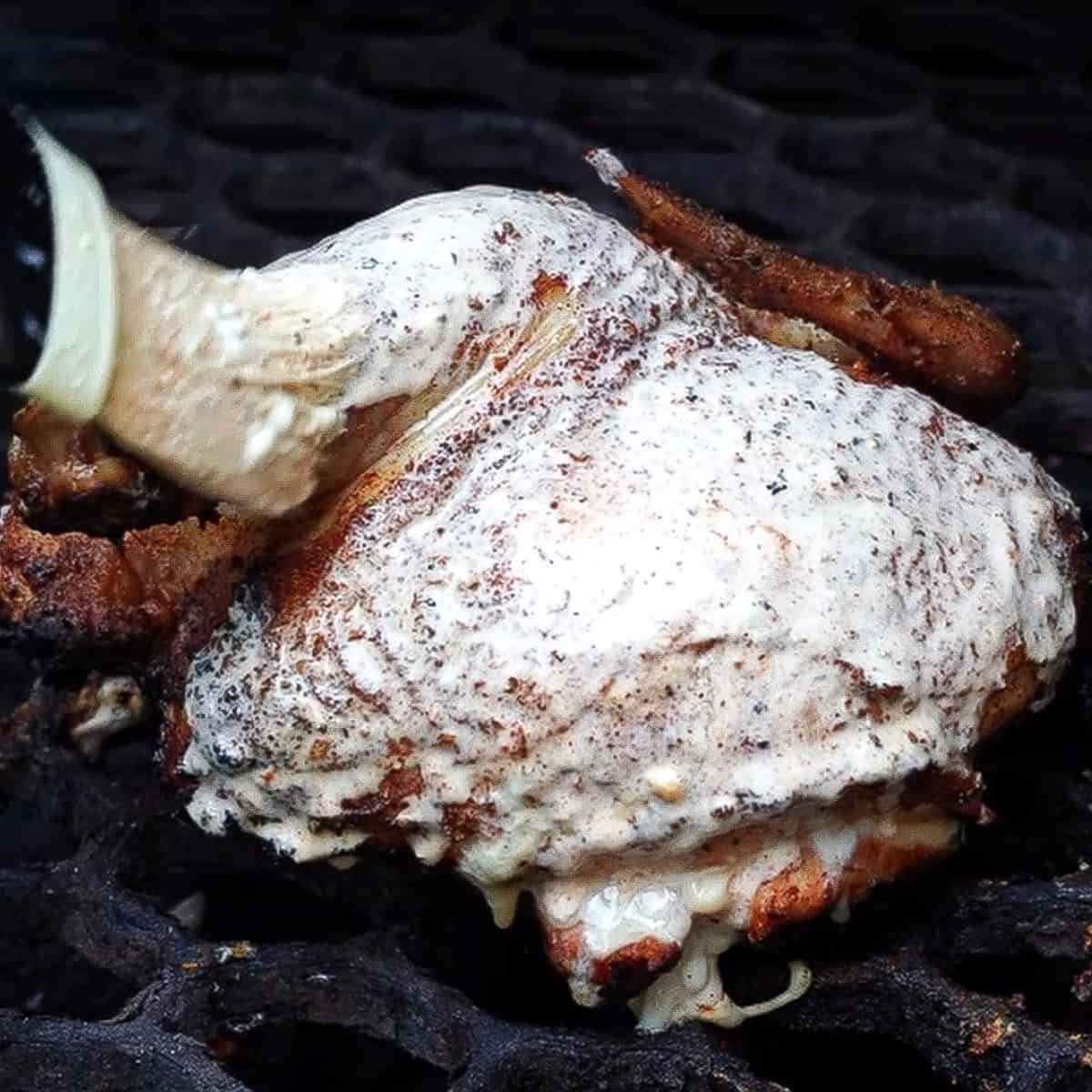 brushing chicken halves with georgia white sauce