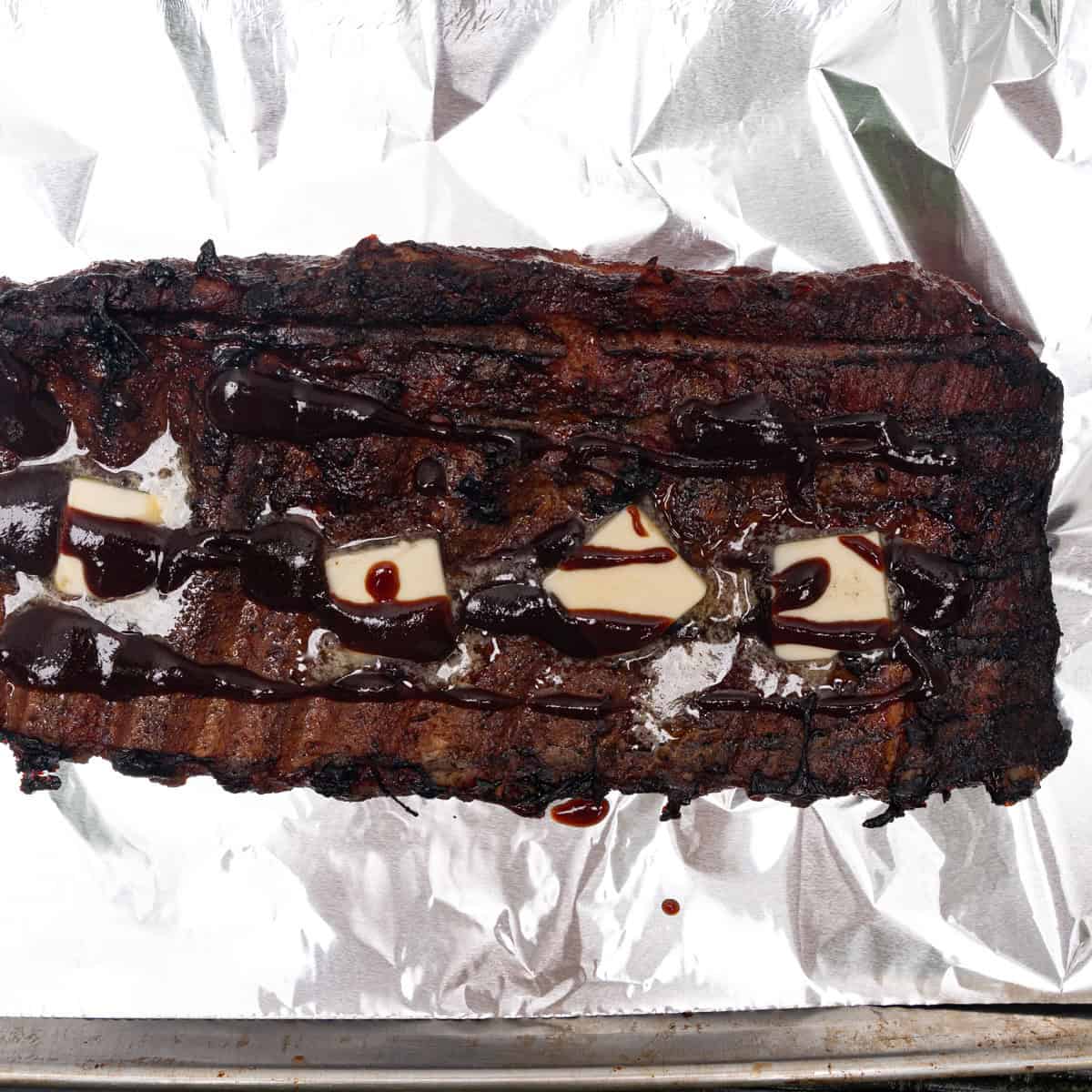 Ribs fresh off the smoker being wrapped in butter & BBQ sauce