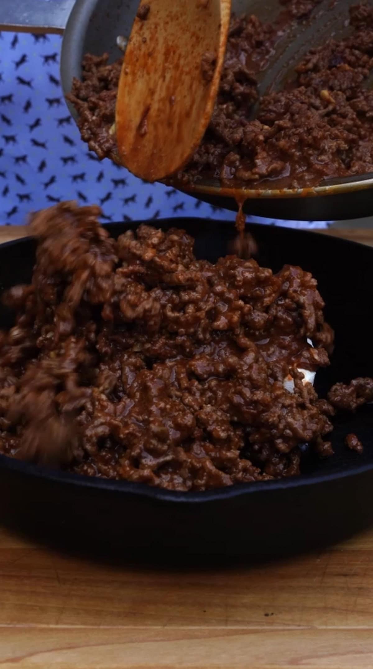 Pouring the chili base into a skillet with cream cheese to prepare the dip