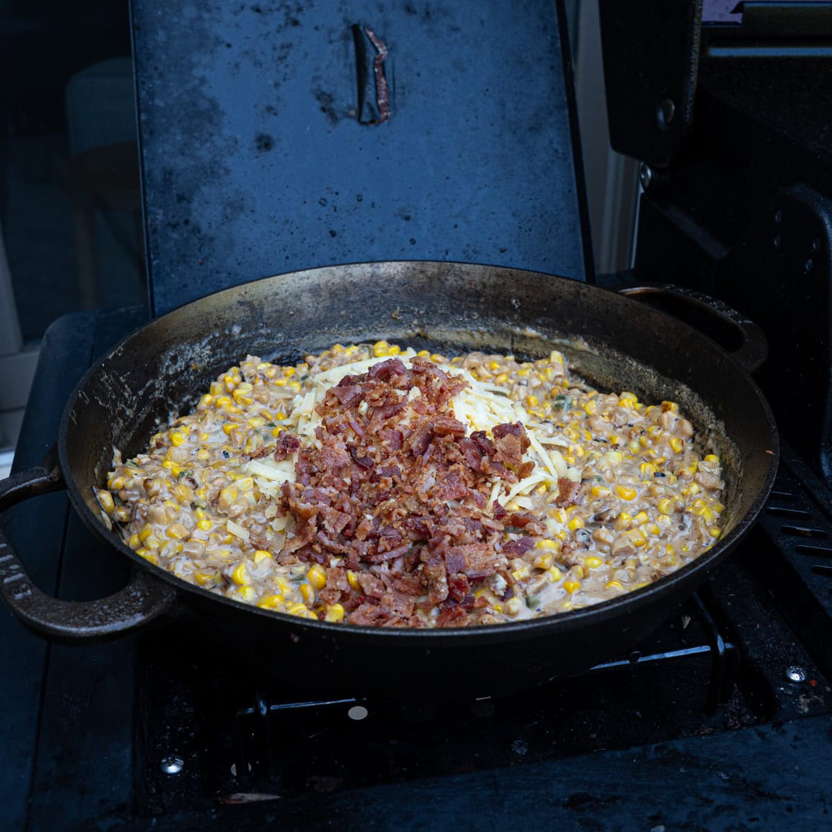Adding cheese and bacon into the pan off heat