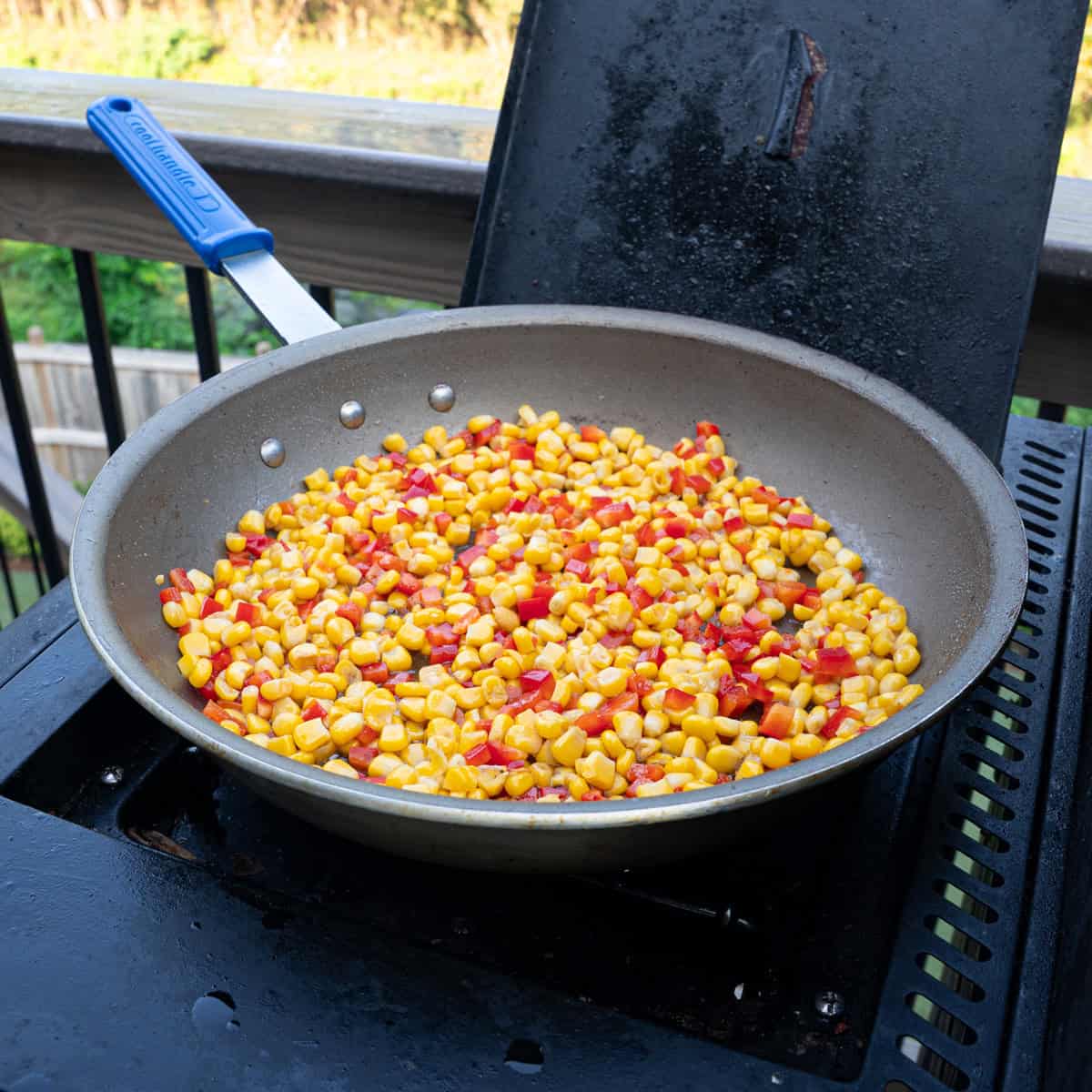 sautéing corn and peppers in a skillet