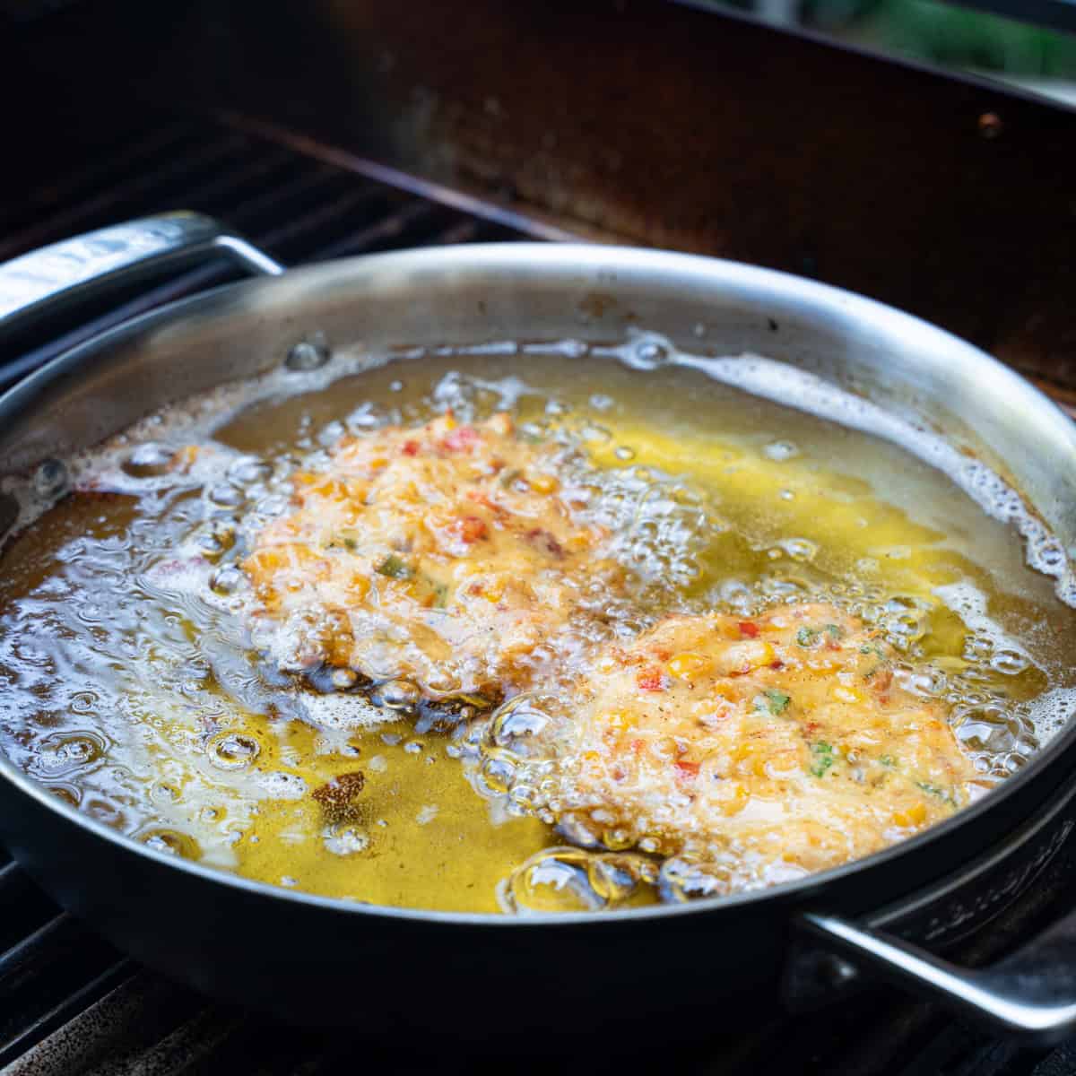 Frying corn and bacon fritters in a skillet