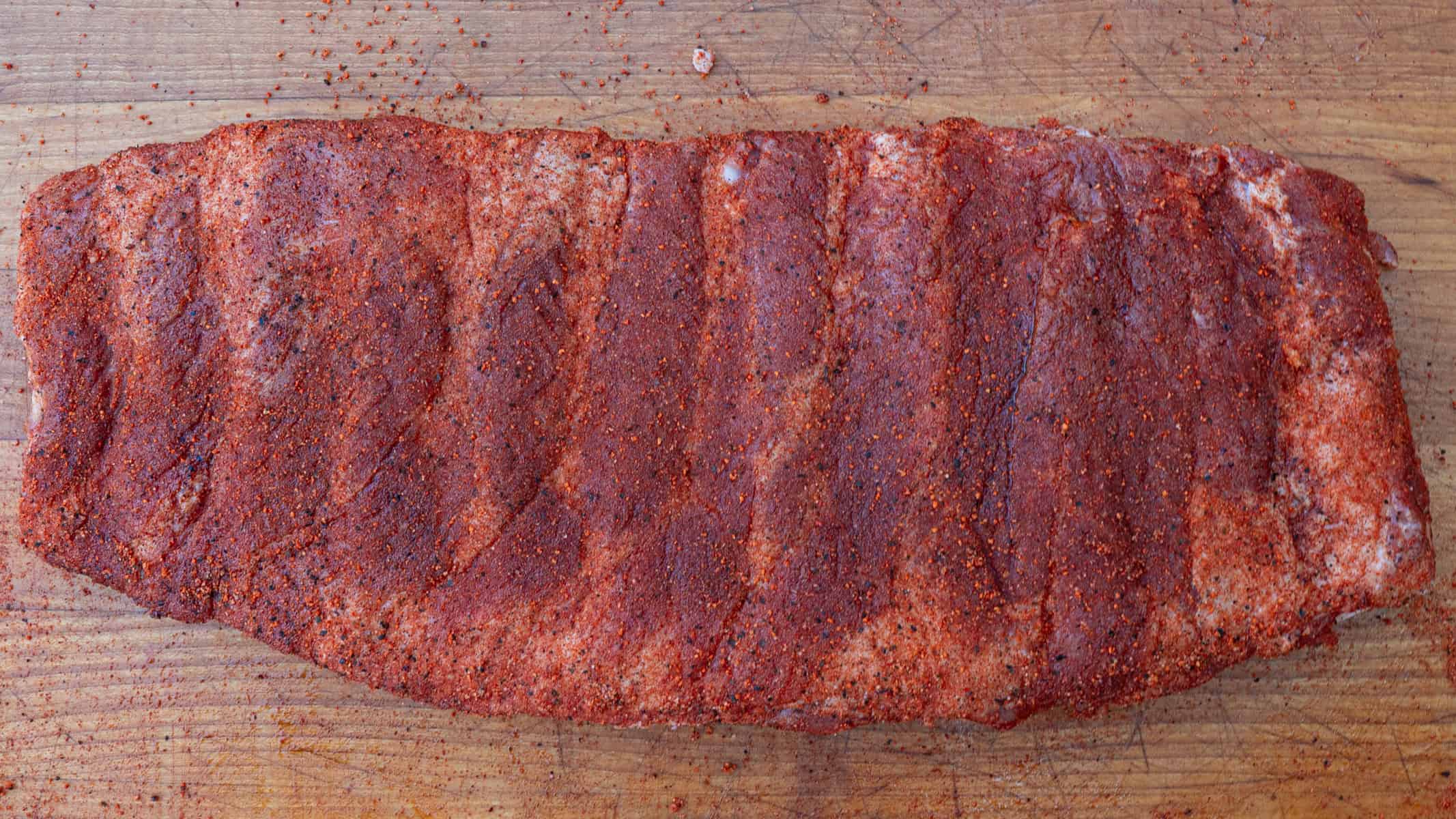 seasoned ribs getting ready to go on the smoker