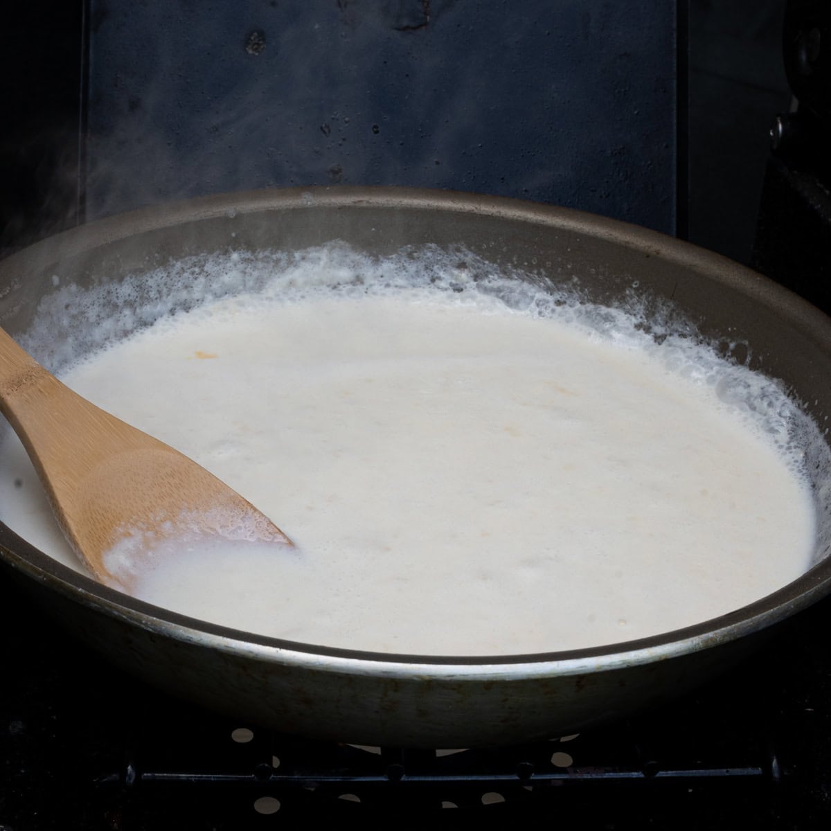 Reducing the liquids into the light roux to continue forming the cream sauce