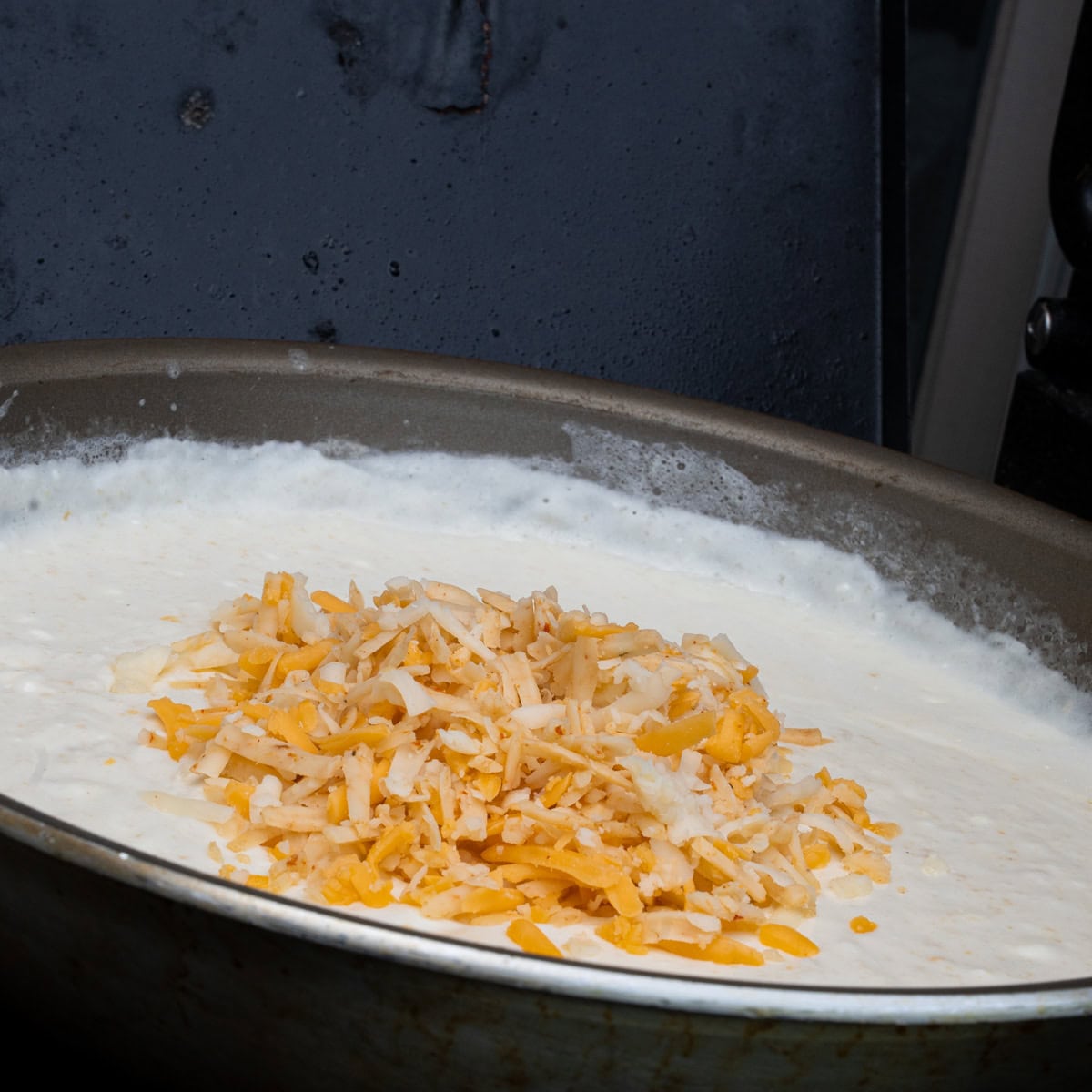 Adding the cheese into the cream sauce
