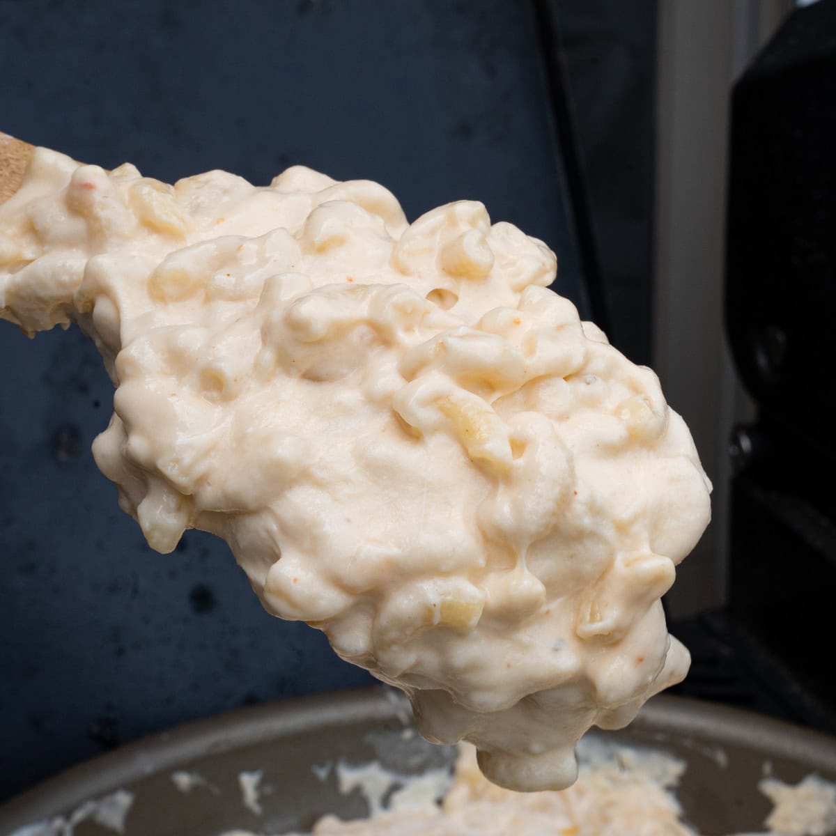 Mixing the macaroni pasta into the cheesy, cream sauce