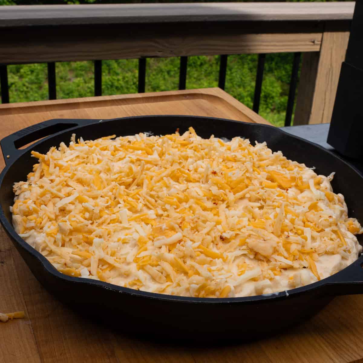 Topping the prepared macaroni and cheese with more cheese to melt in the oven