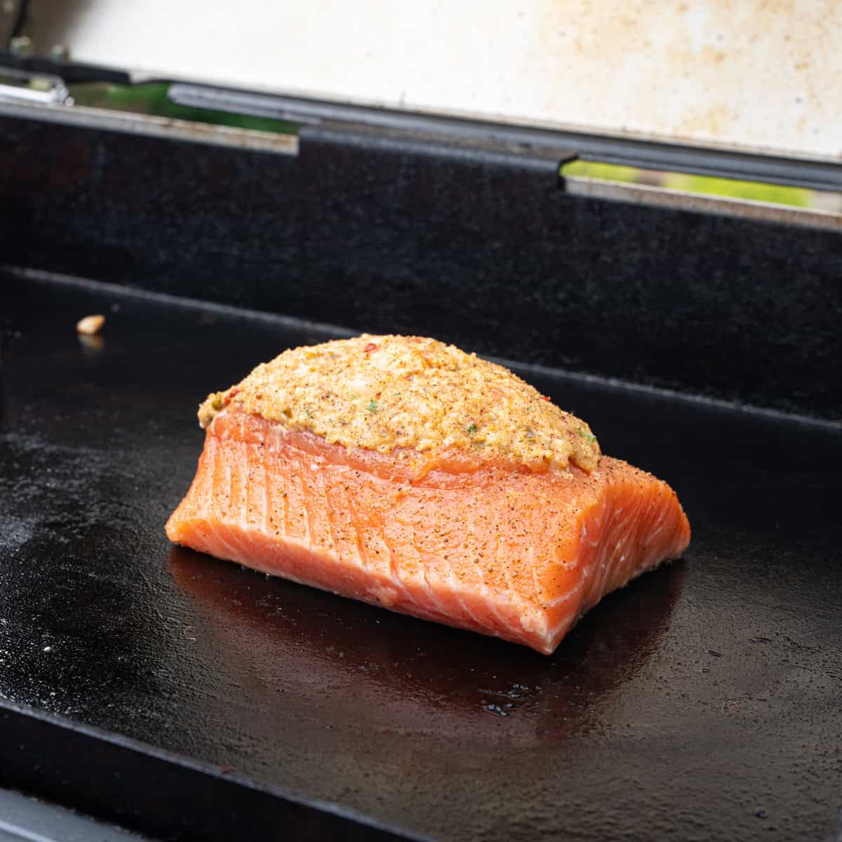 Stuffed salmon placed on the griddle to begin cooking