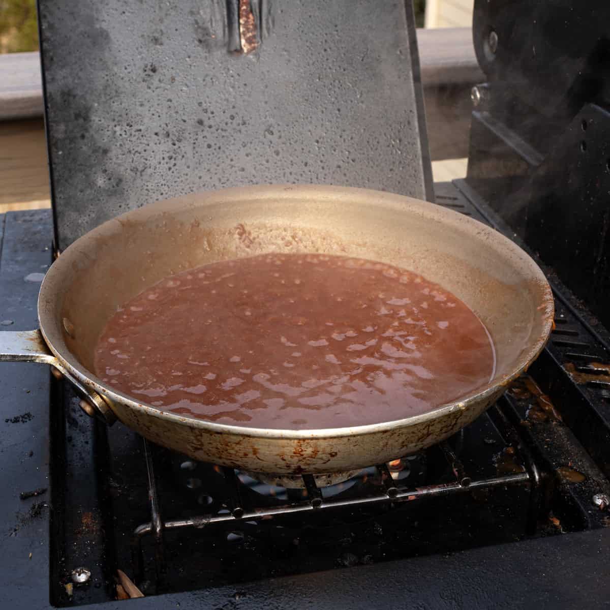 Brown gravy reducing in a saucepan