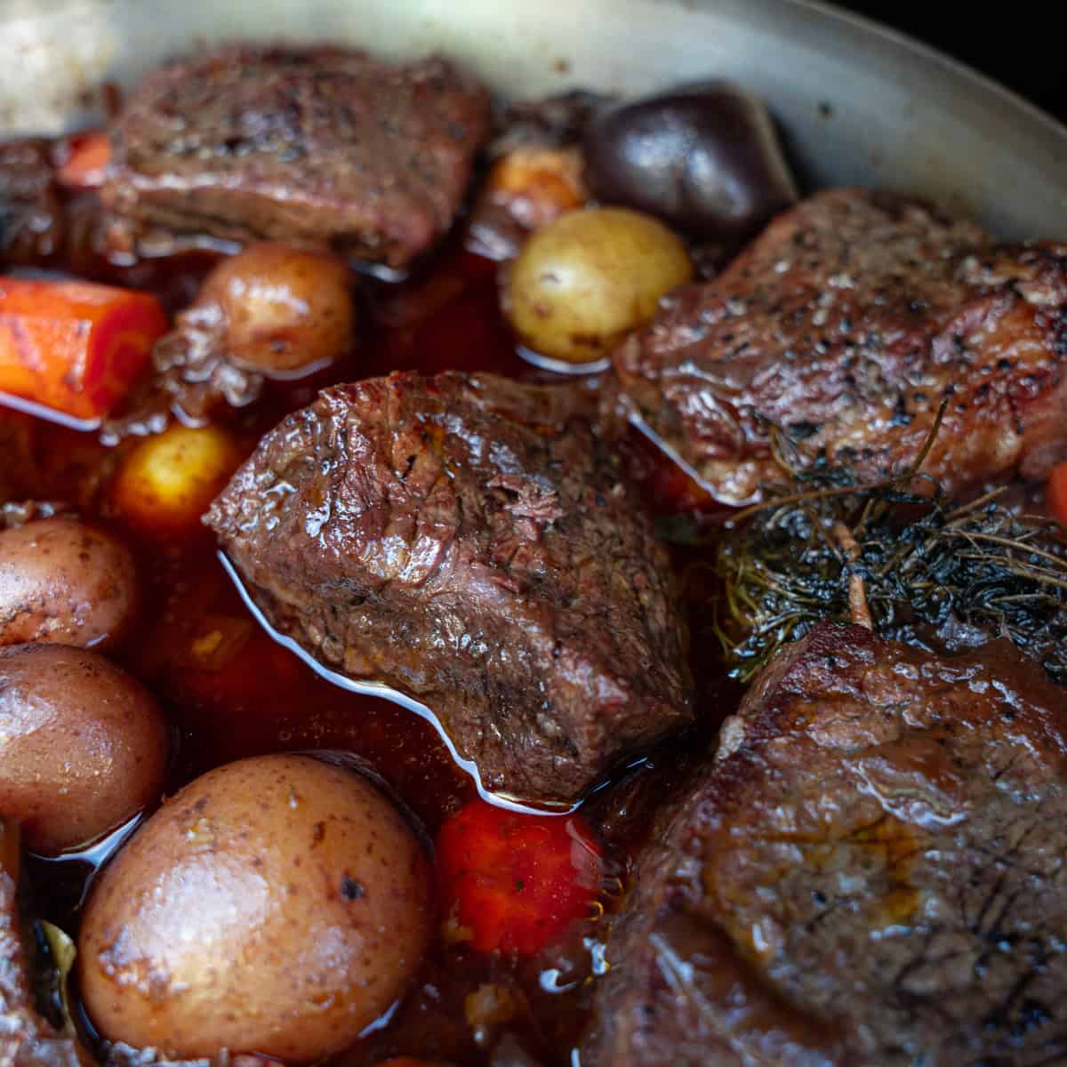 Bottom round roast braising in a large skillet