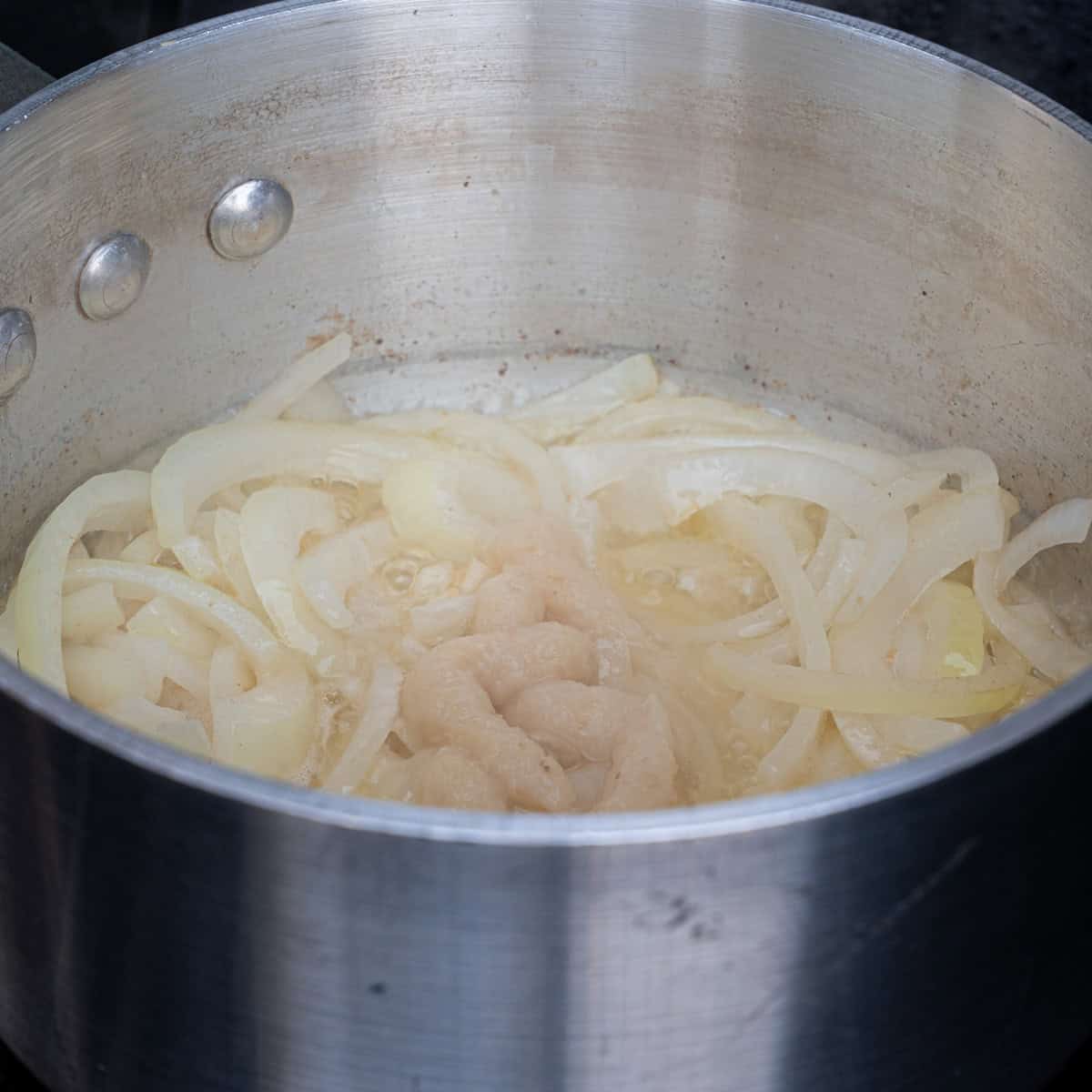 Garlic paste added to saucepan after onions have sweated