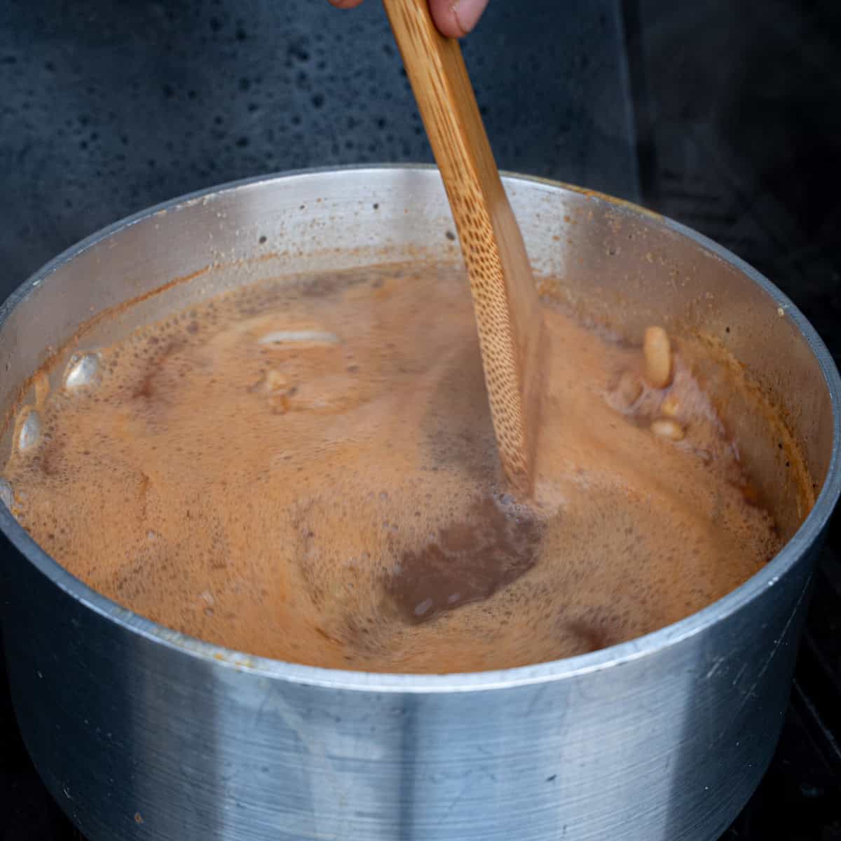 Stirring a simmering saucepan of mop sauce