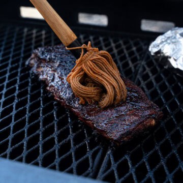 Direct Heat Ribs with a fresh coat of mop sauce being applied