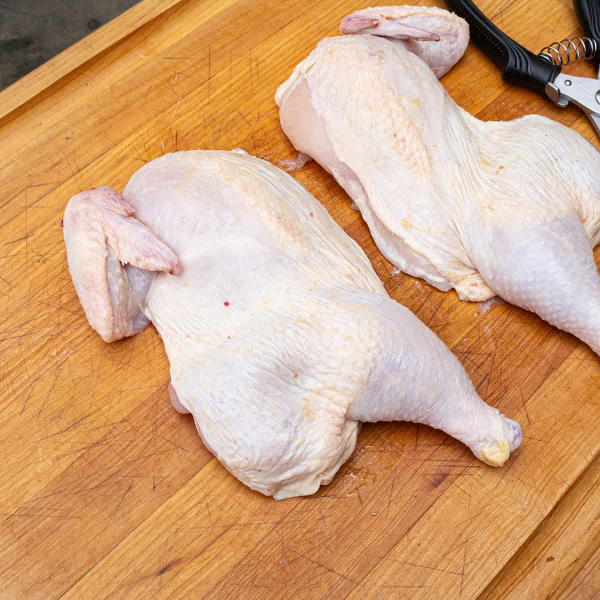 A raw chicken sliced in half