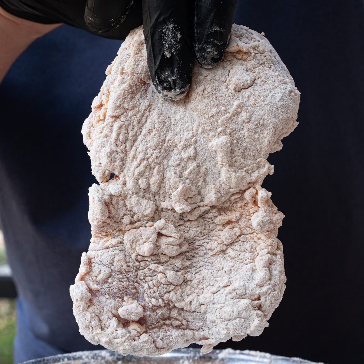 Chicken thighs freshly dredged in flour, cornstarch, and seasonings