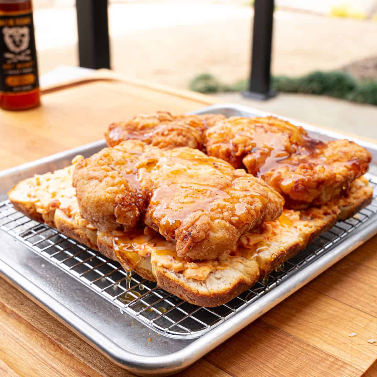 Hot honey being added on top of fried chicken sliders