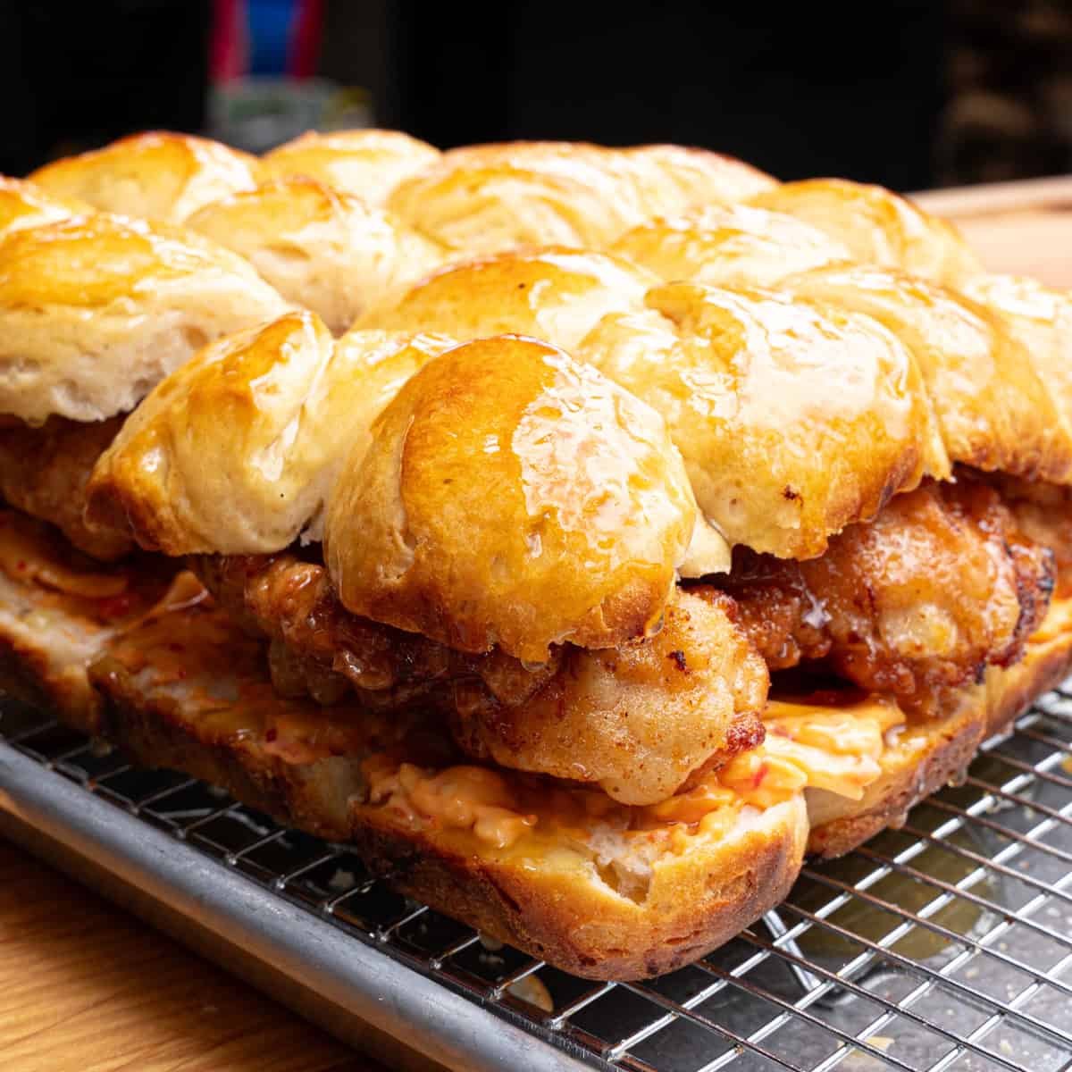 Chicken biscuit sliders right after honey butter was brushed onto the top of the biscuits