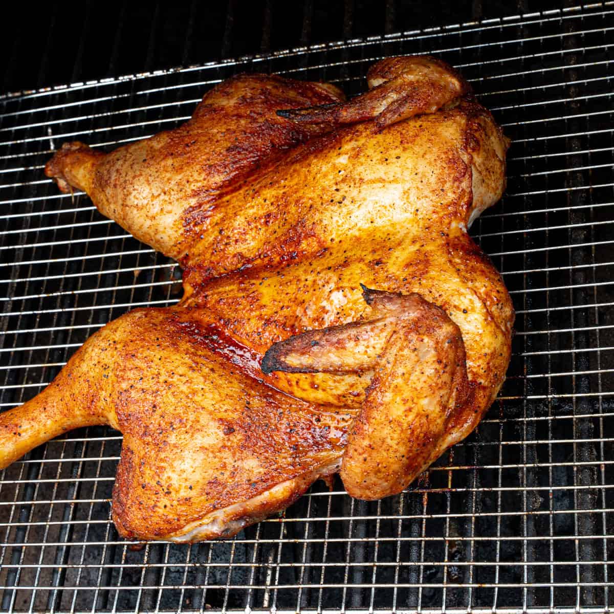 Spatchcock chicken smoking on a pellet grill