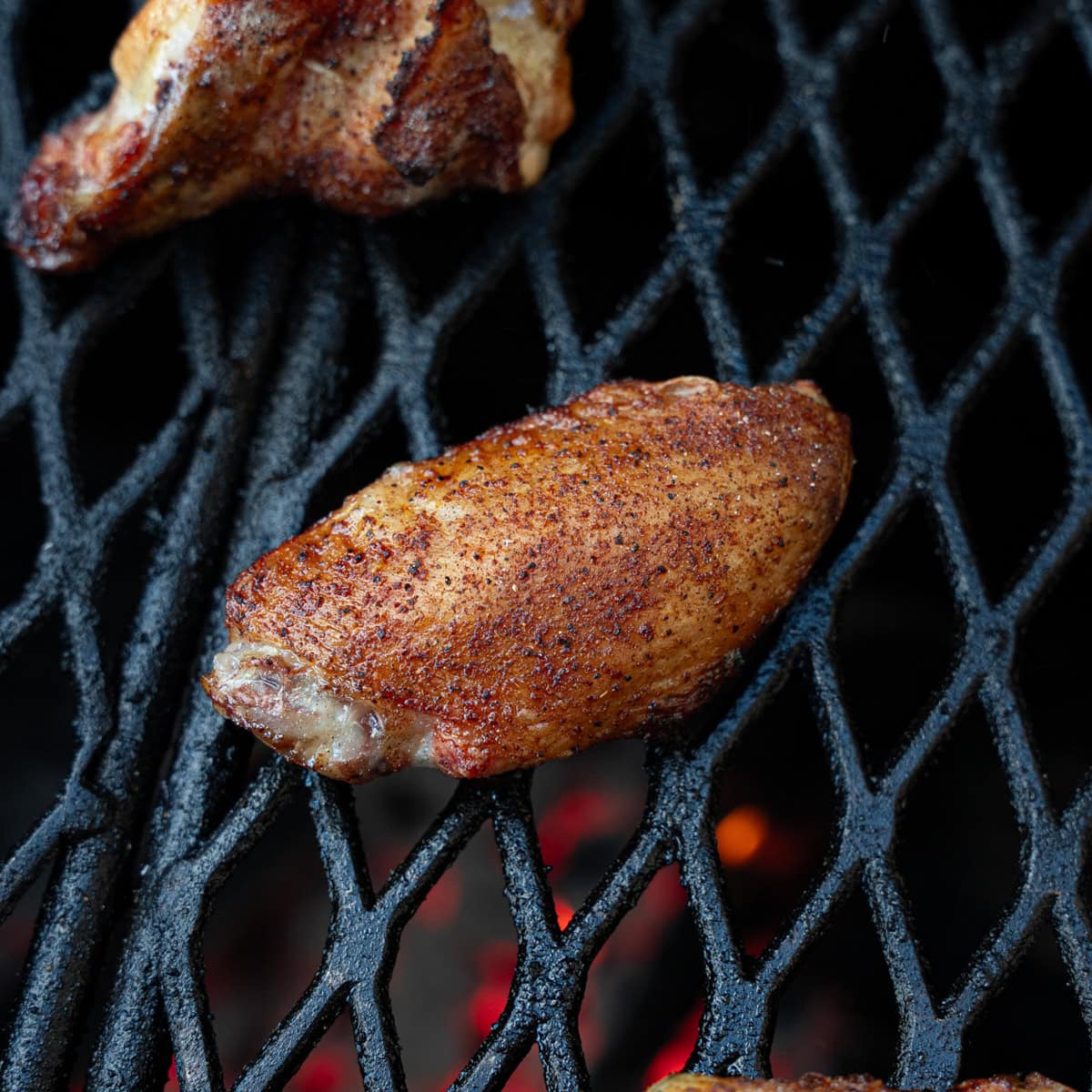 Chicken wing that has been cooking for a short period of time over direct heat