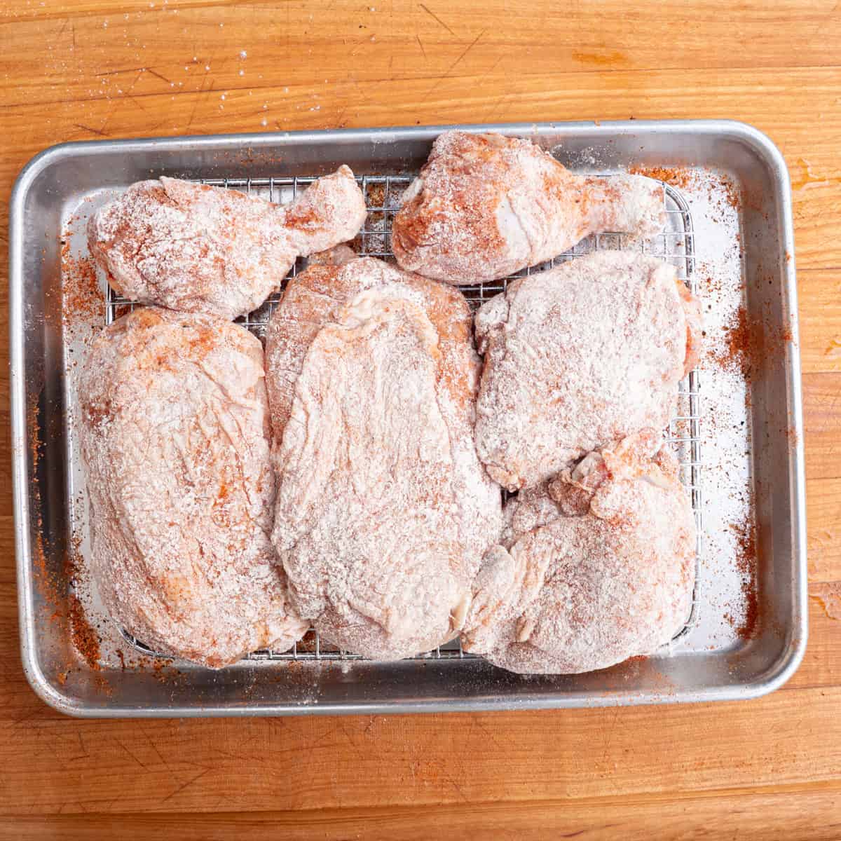 Freshly breaded and seasoned chicken parts ready to be pan seared