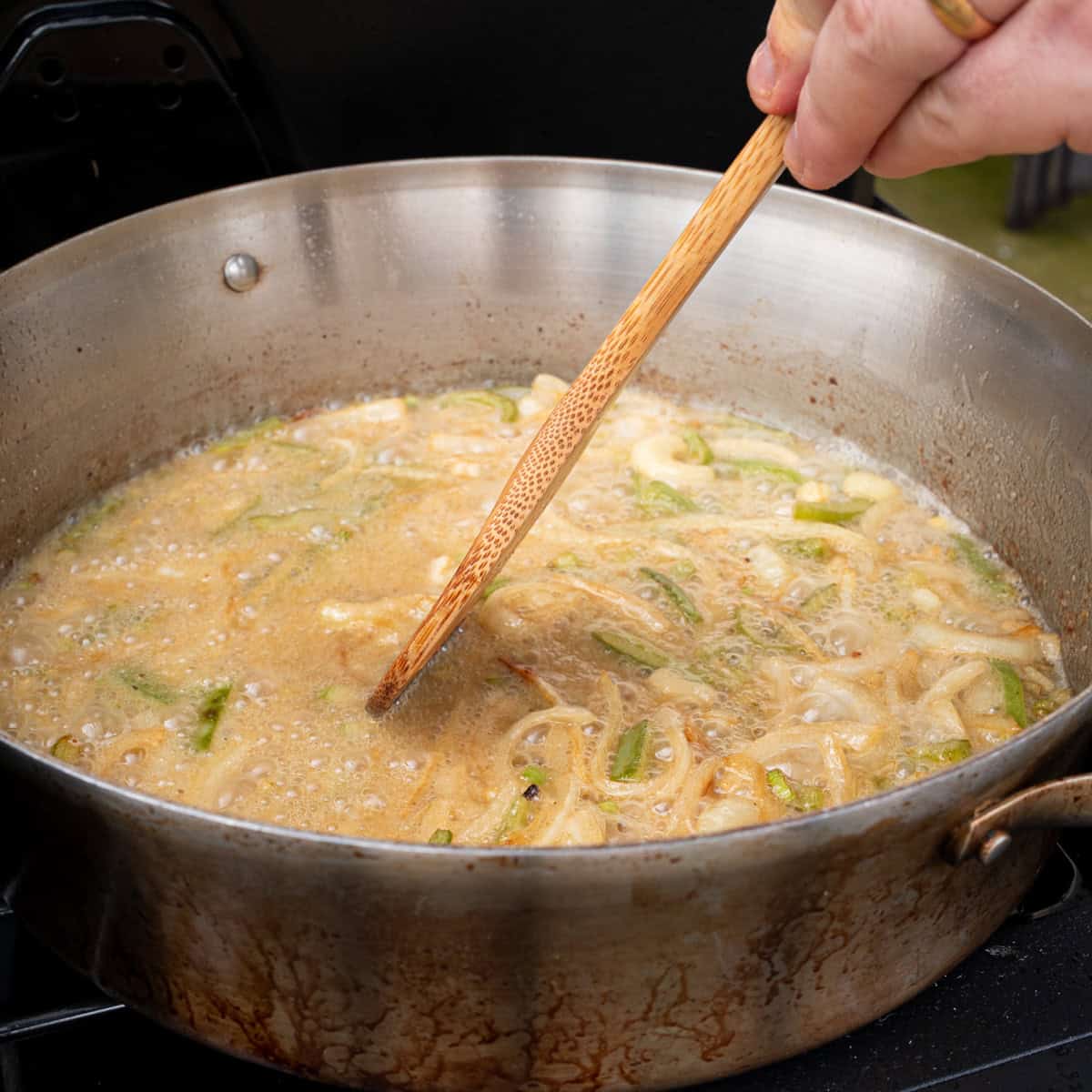 Stirring the flour and oil to form the roux for the chicken gravy after sautéing the vegetables
