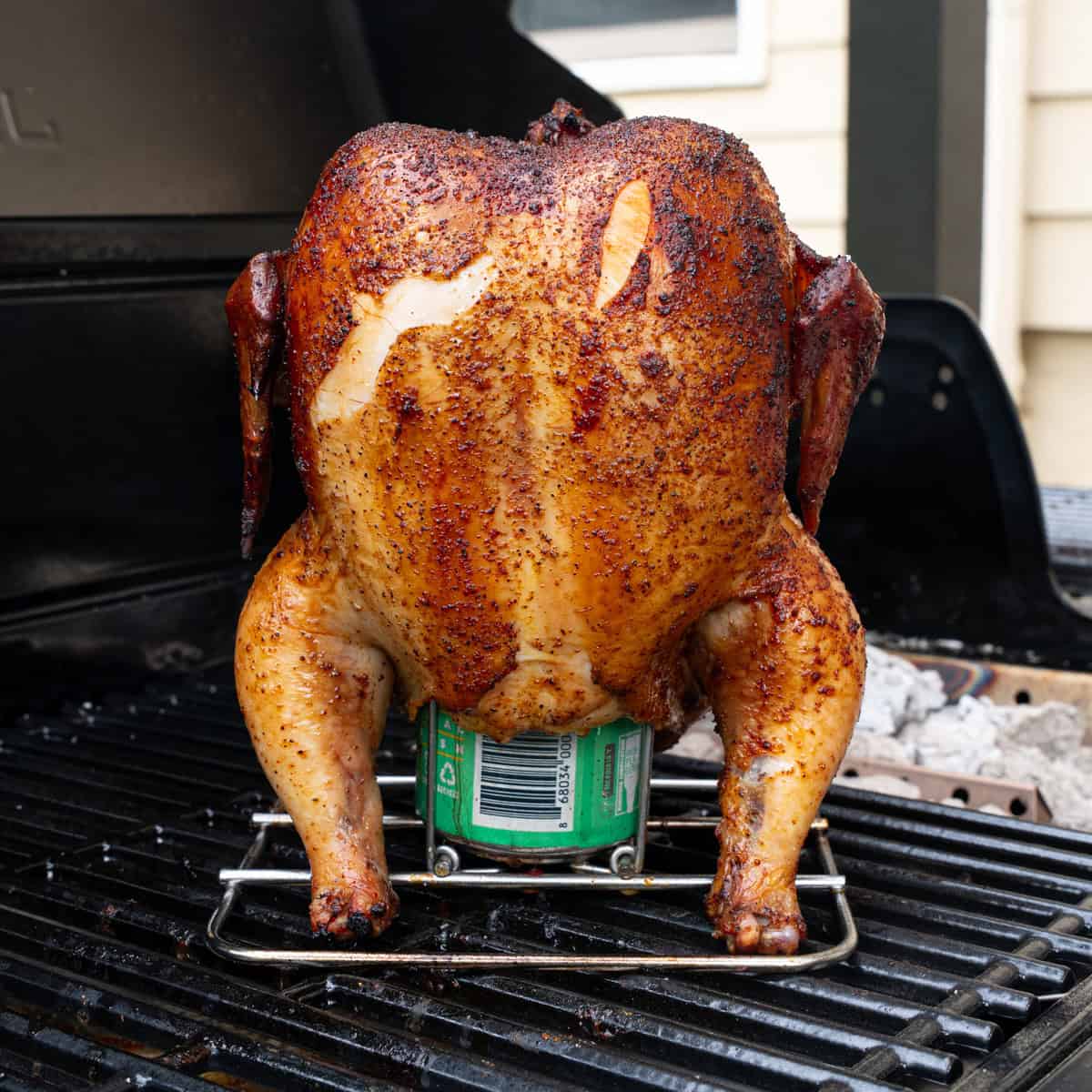 Smoked Beer can chicken on the grill before being glazed with BBQ sauce